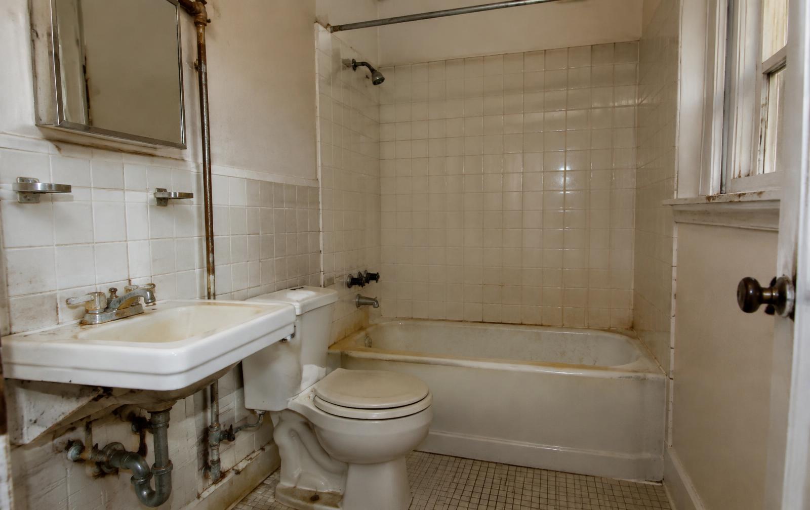 Bathroom before remodel with corroded pipes